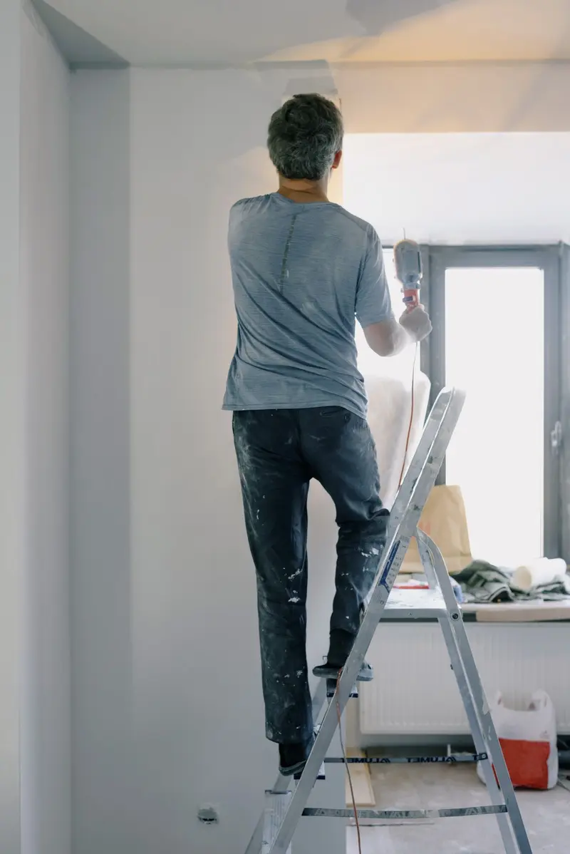 Handyman working from a ladder on an interior repair