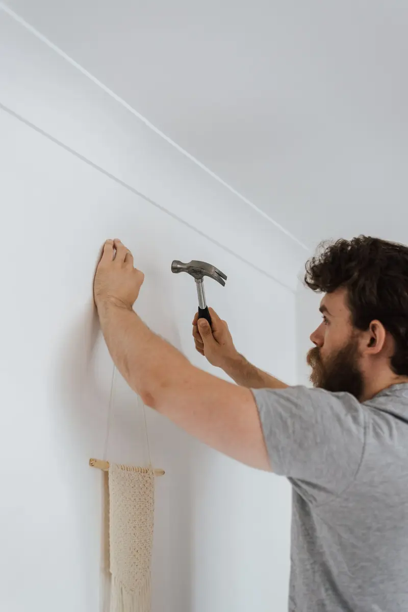 A craftsman doing finish work on an interior wall