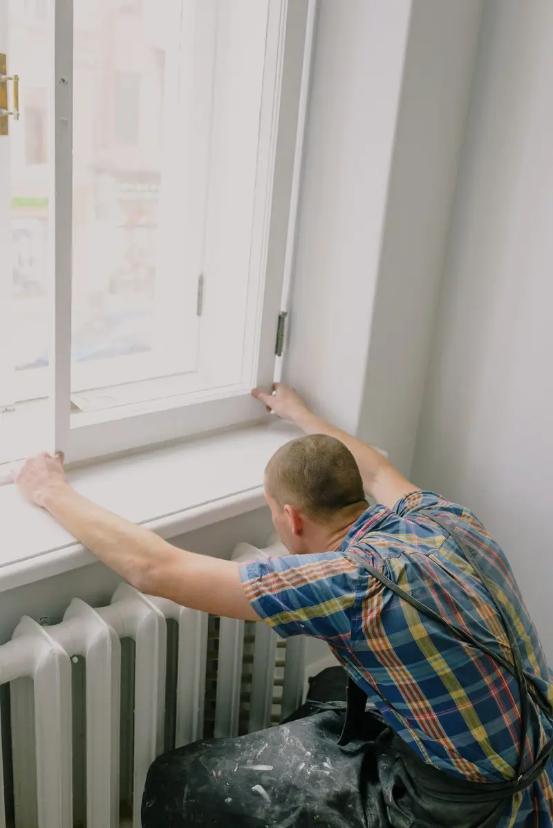 A worker setting and sealing a new window