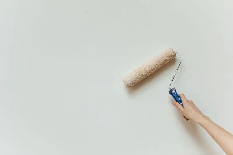 A roller laying fresh paint onto an interior wall